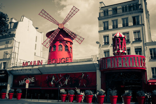 Parísarborgarlíf með Moulin Rouge og rauðum framhliðardrögum í hlýju kvöldljósi.