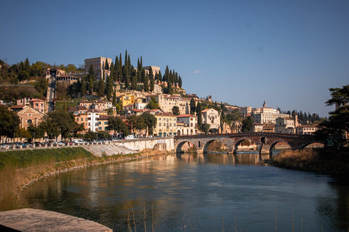 Yfirlitsmynd af Verona með ánni Adige, steinbrú og sögulegum byggingum í hlýju síðdegisljósi