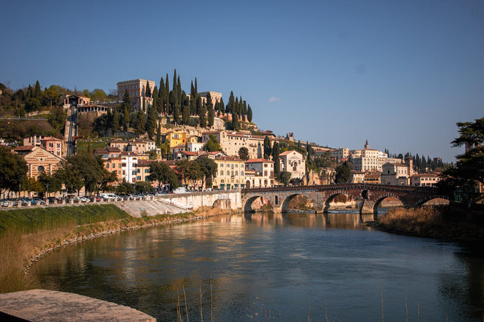 Yfirlitsmynd af Verona með ánni Adige, steinbrú og sögulegum byggingum í hlýju síðdegisljósi